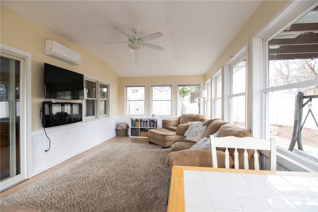 sunroom featuring a wall mounted air conditioner, wainscoting, and vaulted ceiling
