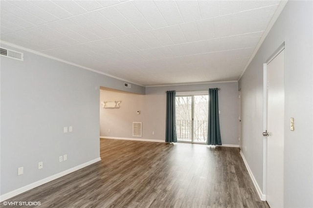spare room featuring visible vents, wood finished floors, baseboards, and ornamental molding