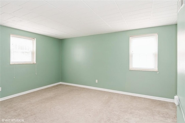 unfurnished room with carpet flooring and baseboards