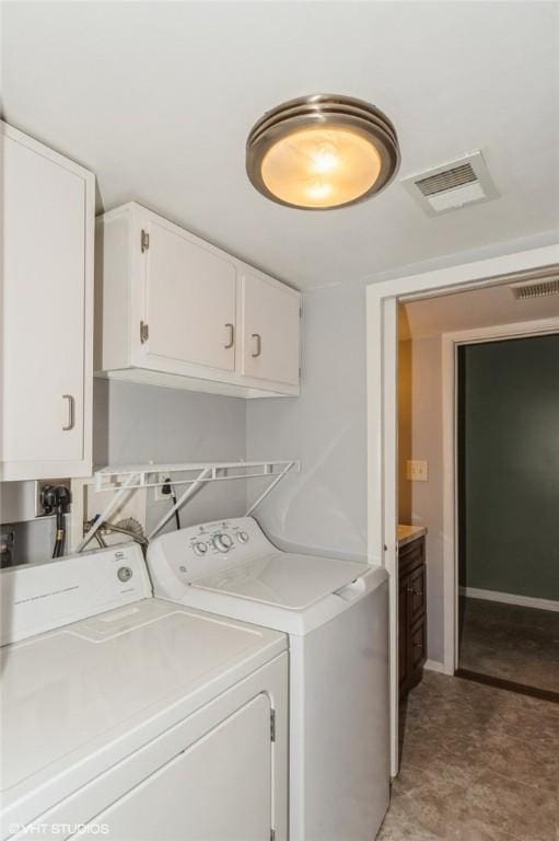 laundry area with baseboards, cabinet space, visible vents, and washing machine and clothes dryer