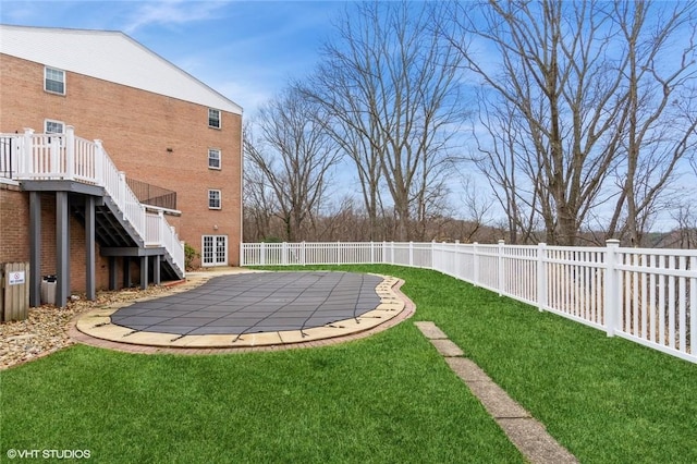 view of yard featuring stairway, a fenced in pool, and a fenced backyard
