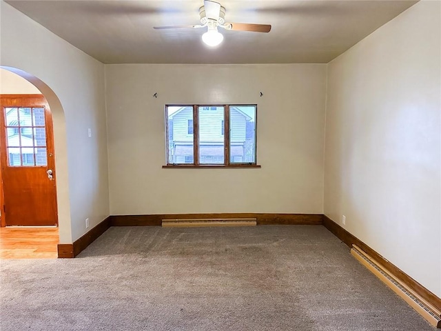 empty room featuring carpet, baseboards, arched walkways, a baseboard radiator, and a ceiling fan