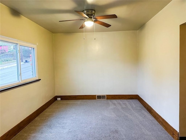 unfurnished room with carpet flooring, a ceiling fan, baseboards, and visible vents
