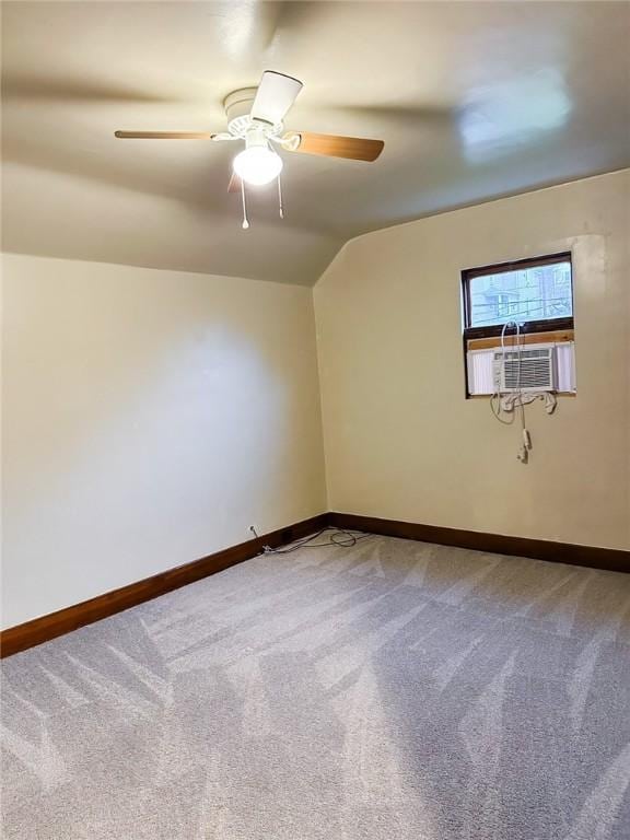 unfurnished room with baseboards, lofted ceiling, cooling unit, and carpet floors