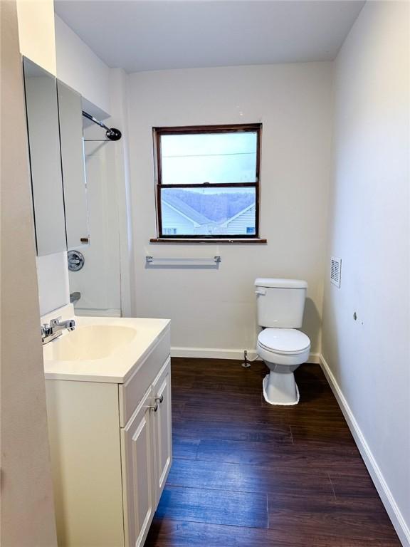 full bath with a shower, vanity, toilet, baseboards, and wood finished floors