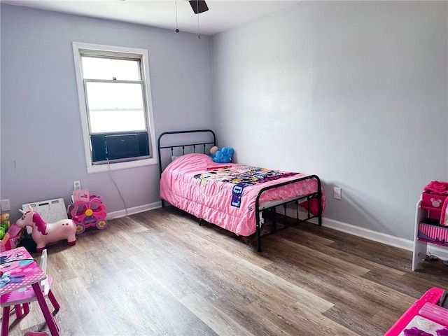 bedroom with baseboards, wood finished floors, and a ceiling fan
