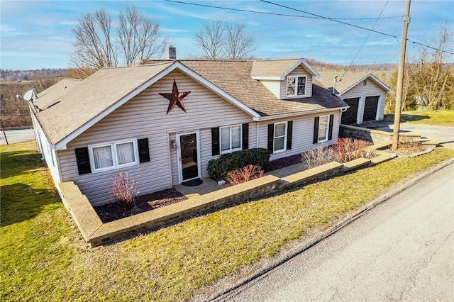view of front of home with an outbuilding, a front yard, roof with shingles, and a chimney