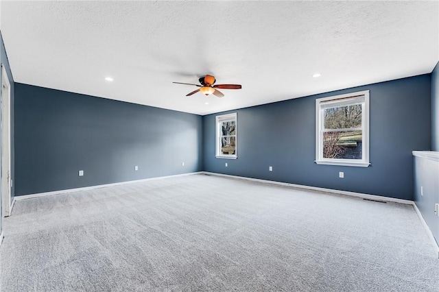 carpeted spare room featuring recessed lighting, a textured ceiling, baseboards, and a ceiling fan
