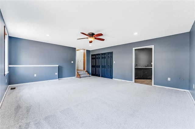 unfurnished bedroom with baseboards, carpet floors, recessed lighting, ceiling fan, and ensuite bathroom