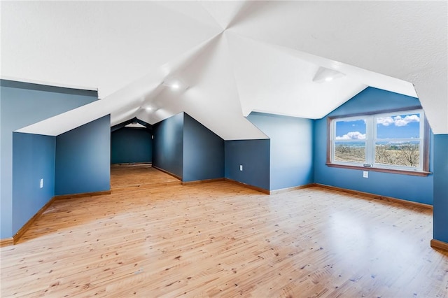 bonus room featuring baseboards, lofted ceiling, and wood finished floors