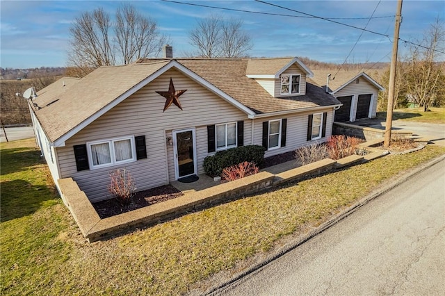 view of front facade featuring an outbuilding, roof with shingles, a chimney, a front lawn, and a garage