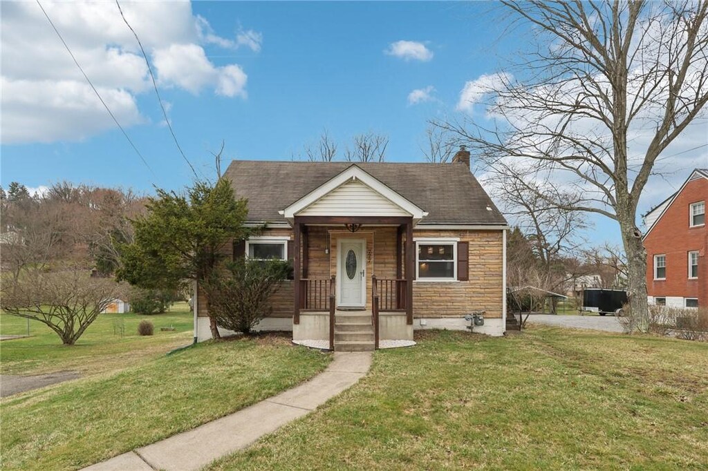bungalow-style house with a chimney, a front lawn, and a shingled roof