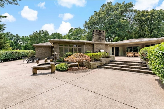 2172 Hycroft Dr, Upper St Clair, PA 15241 - rear view of house featuring a patio area, a chimney, and stone siding