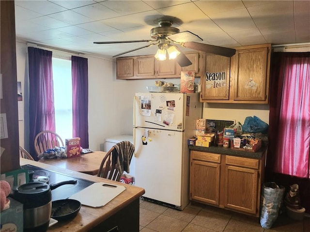 848 Arlington Ave, New Castle/5Th, PA 16101 - kitchen featuring freestanding refrigerator, a ceiling fan, dark countertops, light tile patterned floors, and brown cabinets