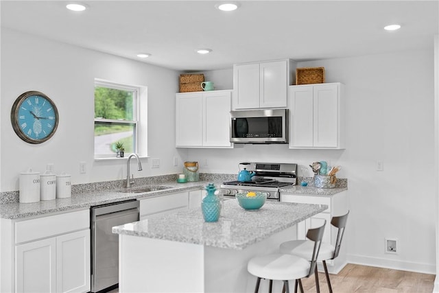 121 Samantha Dr, Center Twp, PA 15061 - kitchen featuring stainless steel appliances, white cabinetry, a breakfast bar, light stone counters, and recessed lighting