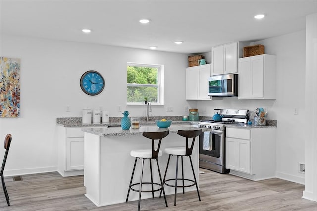 121 Samantha Dr, Center Twp, PA 15061 - kitchen featuring stainless steel appliances, a breakfast bar, light stone countertops, light wood-style flooring, and recessed lighting