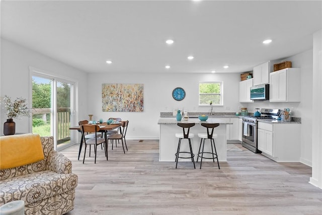121 Samantha Dr, Center Twp, PA 15061 - kitchen featuring stainless steel appliances, a kitchen bar, white cabinets, recessed lighting, and light wood-style flooring