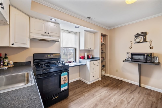 kitchen with black gas range oven, visible vents, ornamental molding, stainless steel microwave, and under cabinet range hood