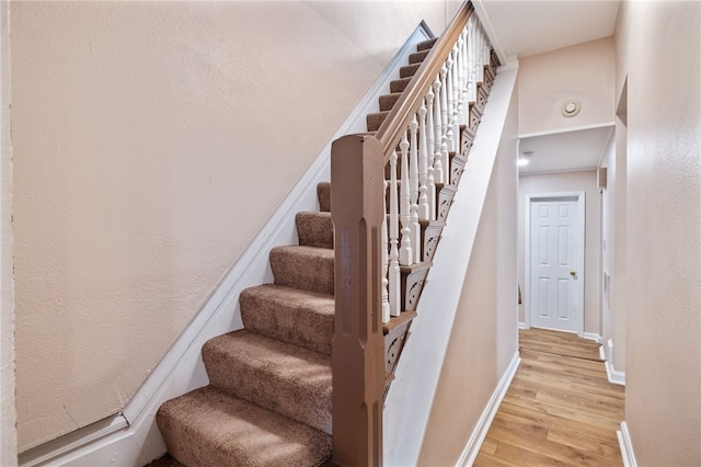 stairs with baseboards and wood finished floors