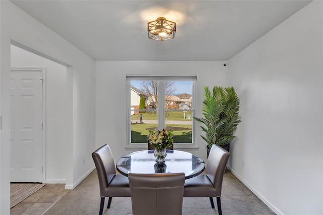 dining space with light colored carpet and baseboards