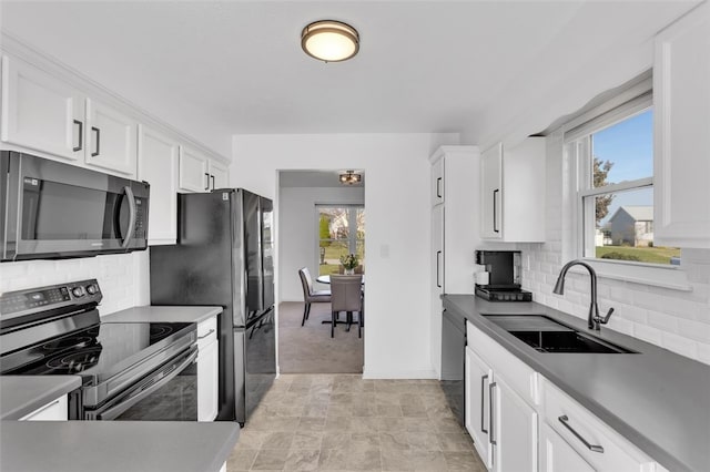 kitchen featuring a healthy amount of sunlight, white cabinetry, stainless steel appliances, and a sink
