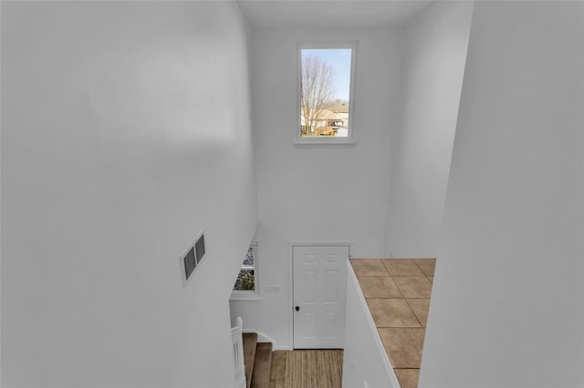 staircase with visible vents and wood finished floors