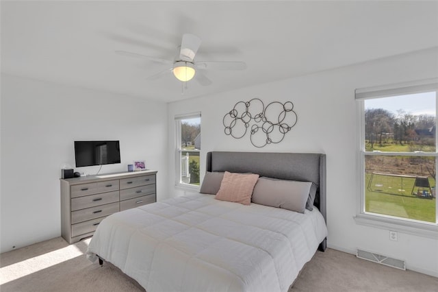 carpeted bedroom featuring visible vents and a ceiling fan