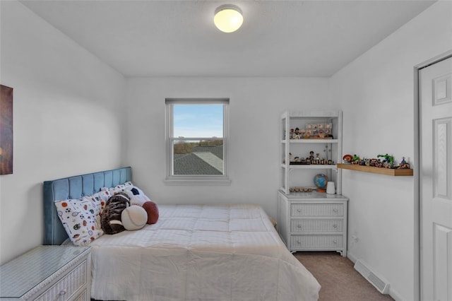 carpeted bedroom featuring visible vents