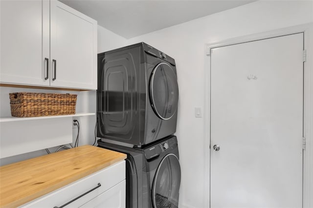 laundry room with stacked washer / dryer and cabinet space