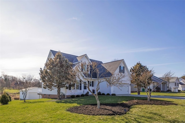view of front of home featuring driveway, an attached garage, and a front lawn