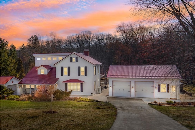 260 Stouffer Hill Rd, Somerset Twp, PA 15541 - view of front of house with an attached garage, a chimney, concrete driveway, a front lawn, and metal roof