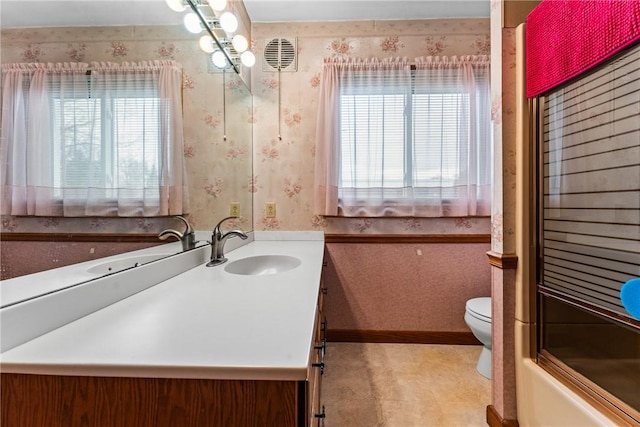 bathroom with wallpapered walls, toilet, vanity, and baseboards