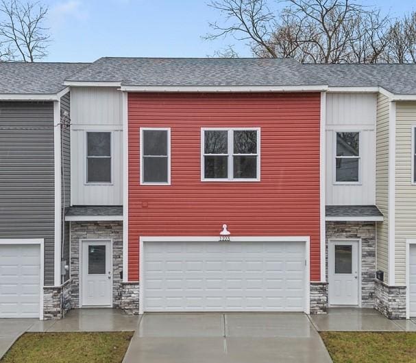 1223 Center Ave, West View, PA 15229 - townhome / multi-family property featuring a garage, stone siding, roof with shingles, and concrete driveway