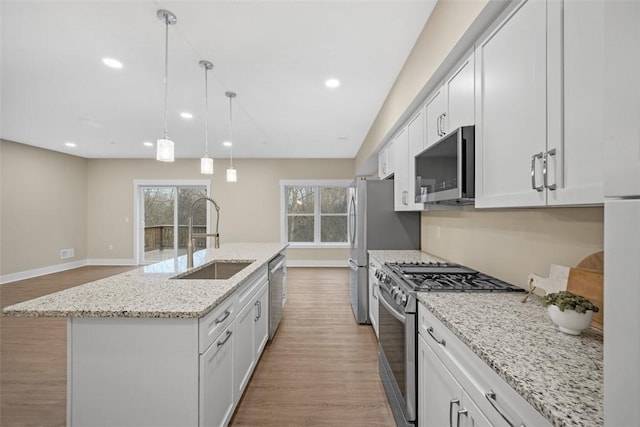 1223 Center Ave, West View, PA 15229 - kitchen with an island with sink, recessed lighting, wood finished floors, stainless steel appliances, and a sink