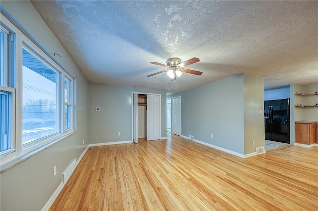 159 Mardi Gras Dr, Plum Boro, PA 15239 - spare room featuring light wood-type flooring, visible vents, a textured ceiling, baseboards, and ceiling fan