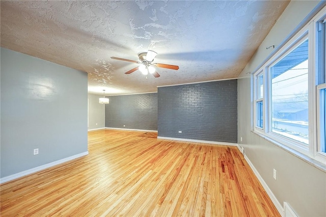 159 Mardi Gras Dr, Plum Boro, PA 15239 - spare room with ceiling fan, light wood-style flooring, brick wall, and a textured ceiling