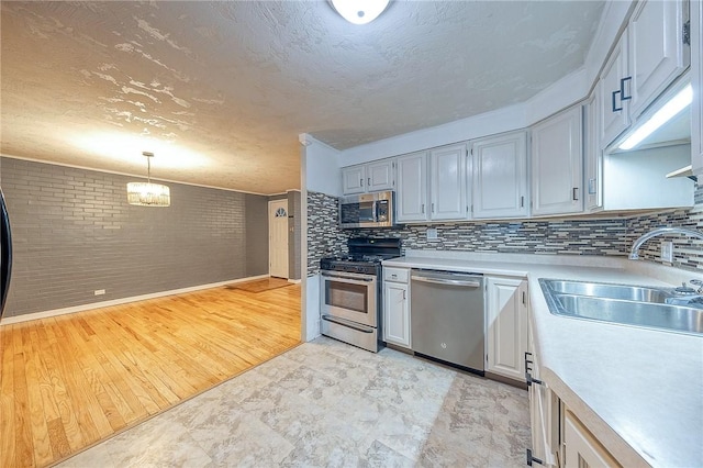 159 Mardi Gras Dr, Plum Boro, PA 15239 - kitchen featuring a sink, decorative light fixtures, a textured ceiling, appliances with stainless steel finishes, and light countertops