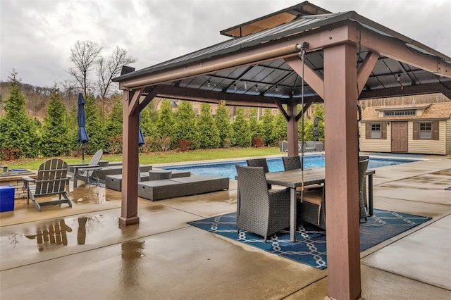 view of patio featuring an outdoor pool, a gazebo, and outdoor dining space