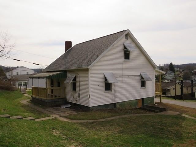 501 Adams St, West Newton, PA 15089 - view of home's exterior featuring a chimney, a yard, a deck, and roof with shingles