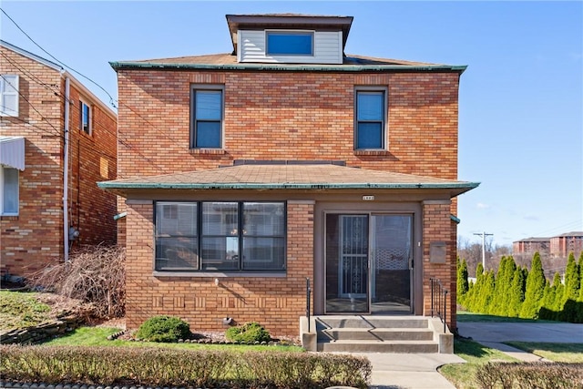 rear view of property with entry steps and brick siding