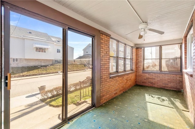 unfurnished sunroom with ceiling fan