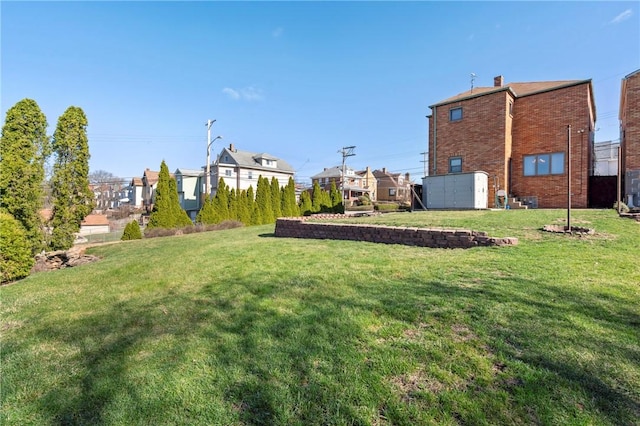 view of yard with a storage shed and a residential view