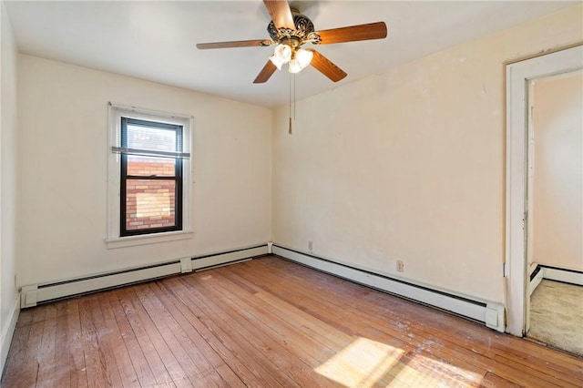 spare room featuring a baseboard radiator, ceiling fan, and hardwood / wood-style floors