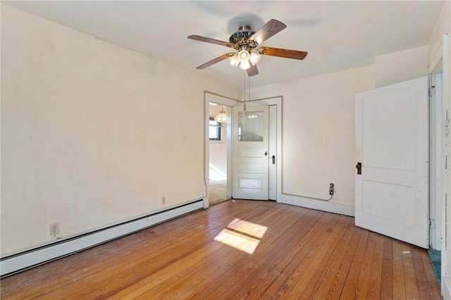 empty room with ceiling fan, baseboard heating, and light wood-style floors