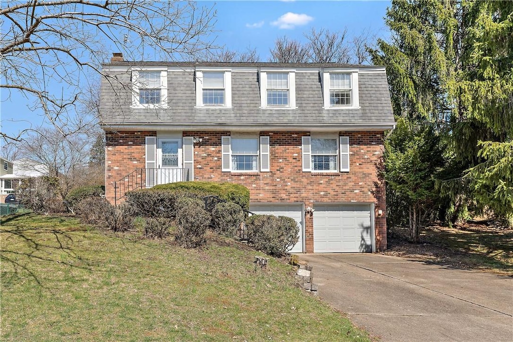 view of front of house with driveway, mansard roof, an attached garage, brick siding, and a shingled roof