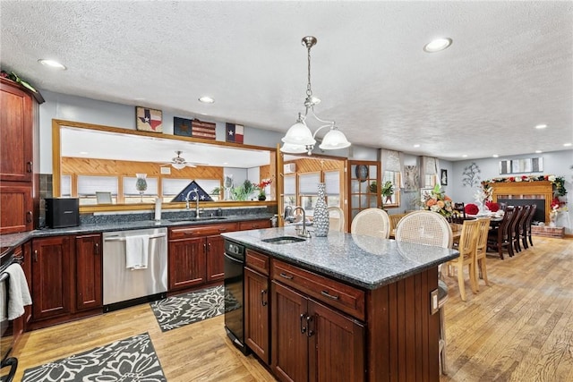 19 Misty Meadows Ln, Menallen Twp, PA 15401 - kitchen with stainless steel dishwasher, light wood finished floors, a textured ceiling, dark stone counters, and a kitchen island with sink