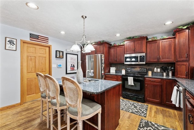 19 Misty Meadows Ln, Menallen Twp, PA 15401 - kitchen with stainless steel appliances, backsplash, a chandelier, light wood-type flooring, and dark brown cabinets