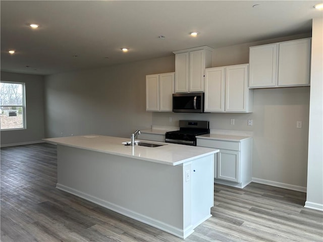 kitchen featuring appliances with stainless steel finishes, a sink, baseboards, and recessed lighting