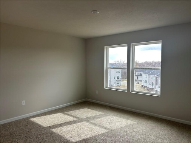 unfurnished room with light colored carpet and baseboards