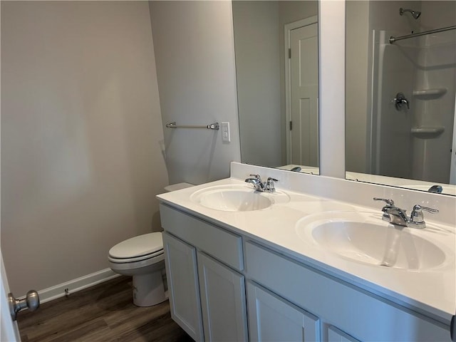 bathroom with toilet, wood finished floors, a sink, and walk in shower